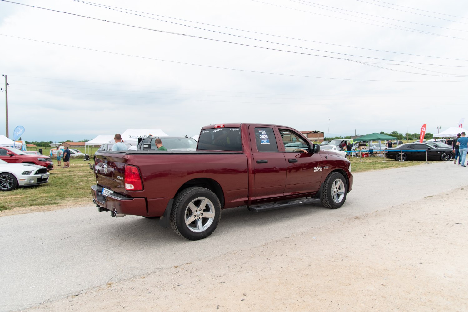 Burgundy 4-door pickup truck with rugged tires and covered bed