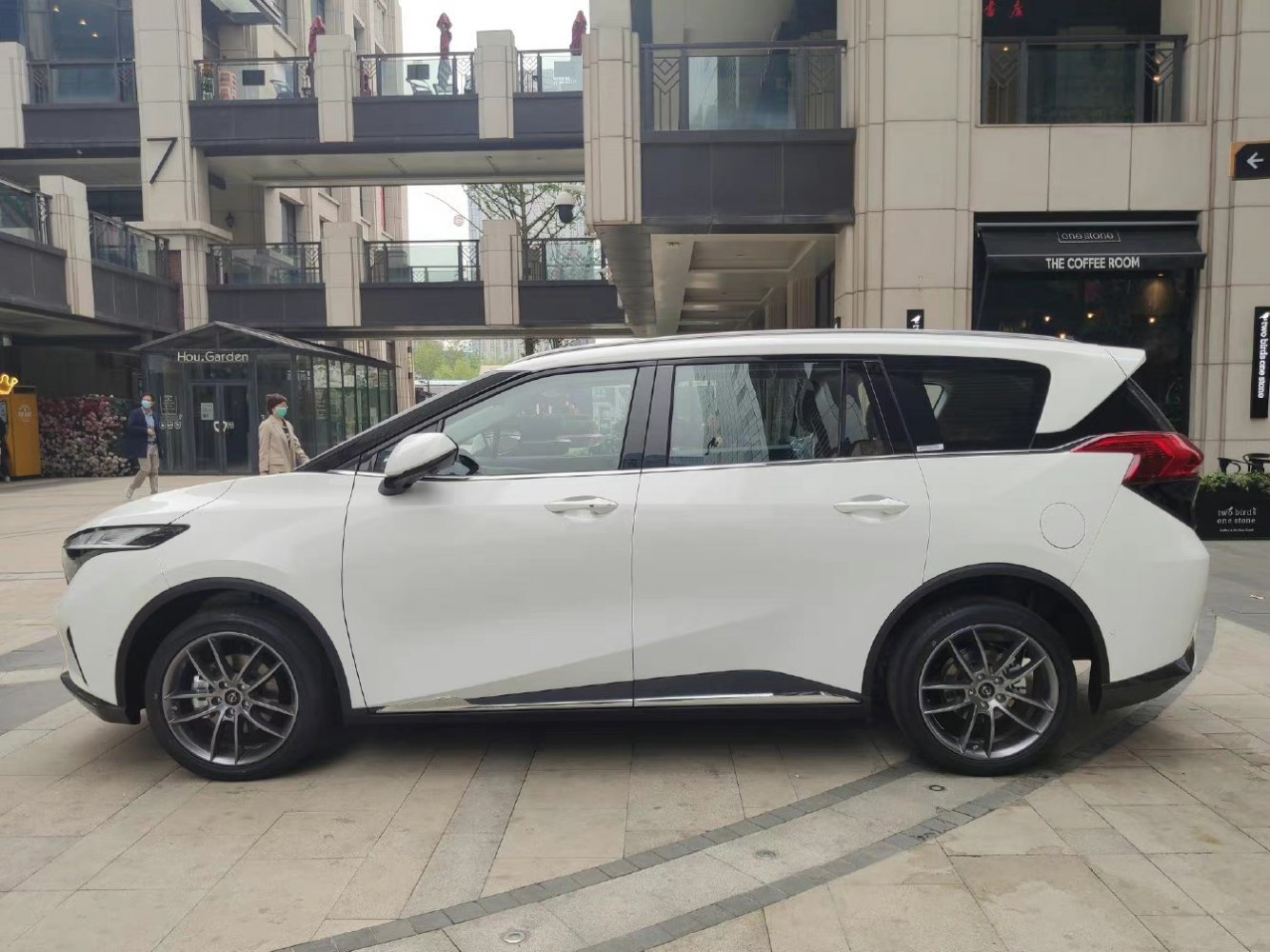 Side profile of a white MPV with alloy wheels and black trim accents
