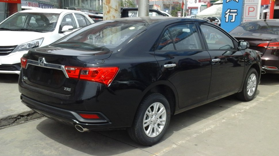 Rear and side view of a black sedan showing tail lights and chrome trim