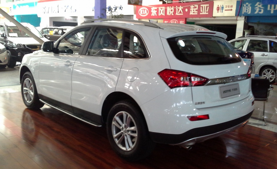 White SUV rear side view with alloy wheels in indoor showroom
