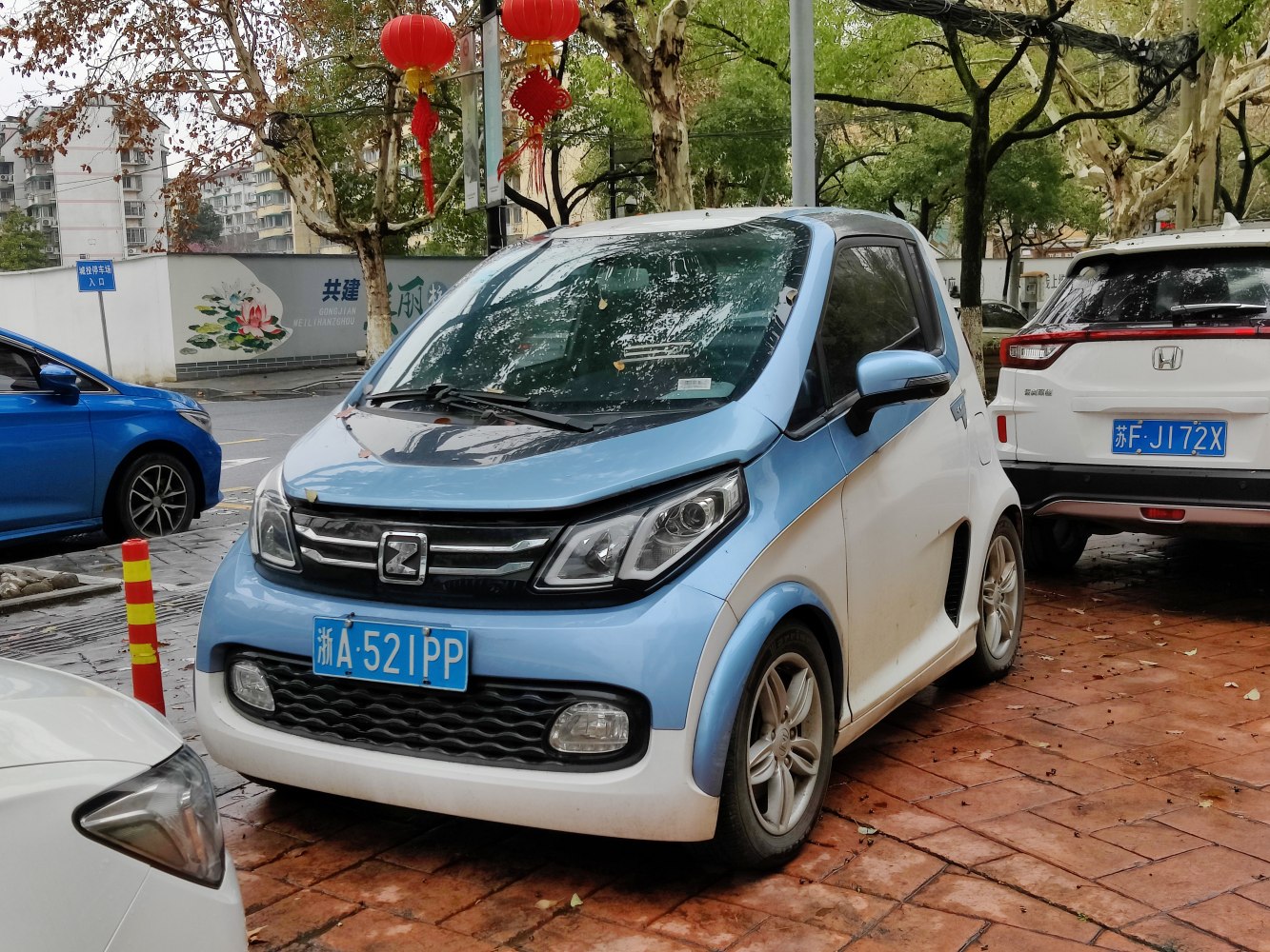 Compact two-tone electric microcar with modern headlight and grille design