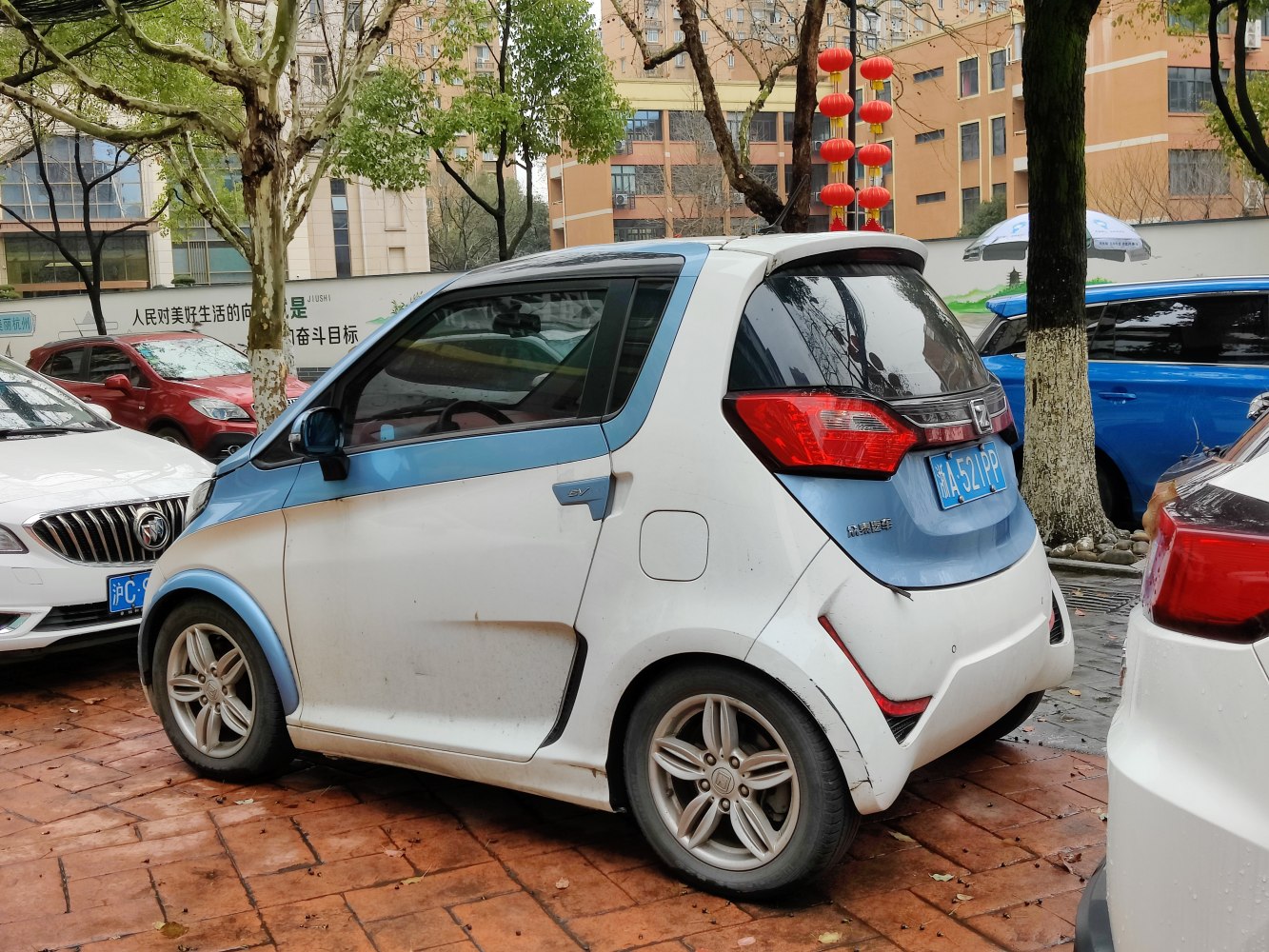 Compact electric microcar with blue accents and modern rear design