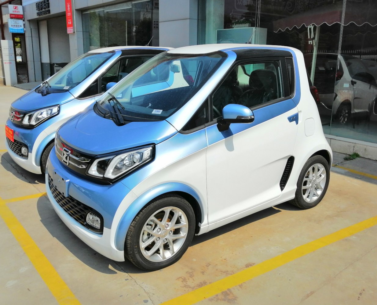 Compact two-tone urban microcar with distinctive headlights and sporty wheels