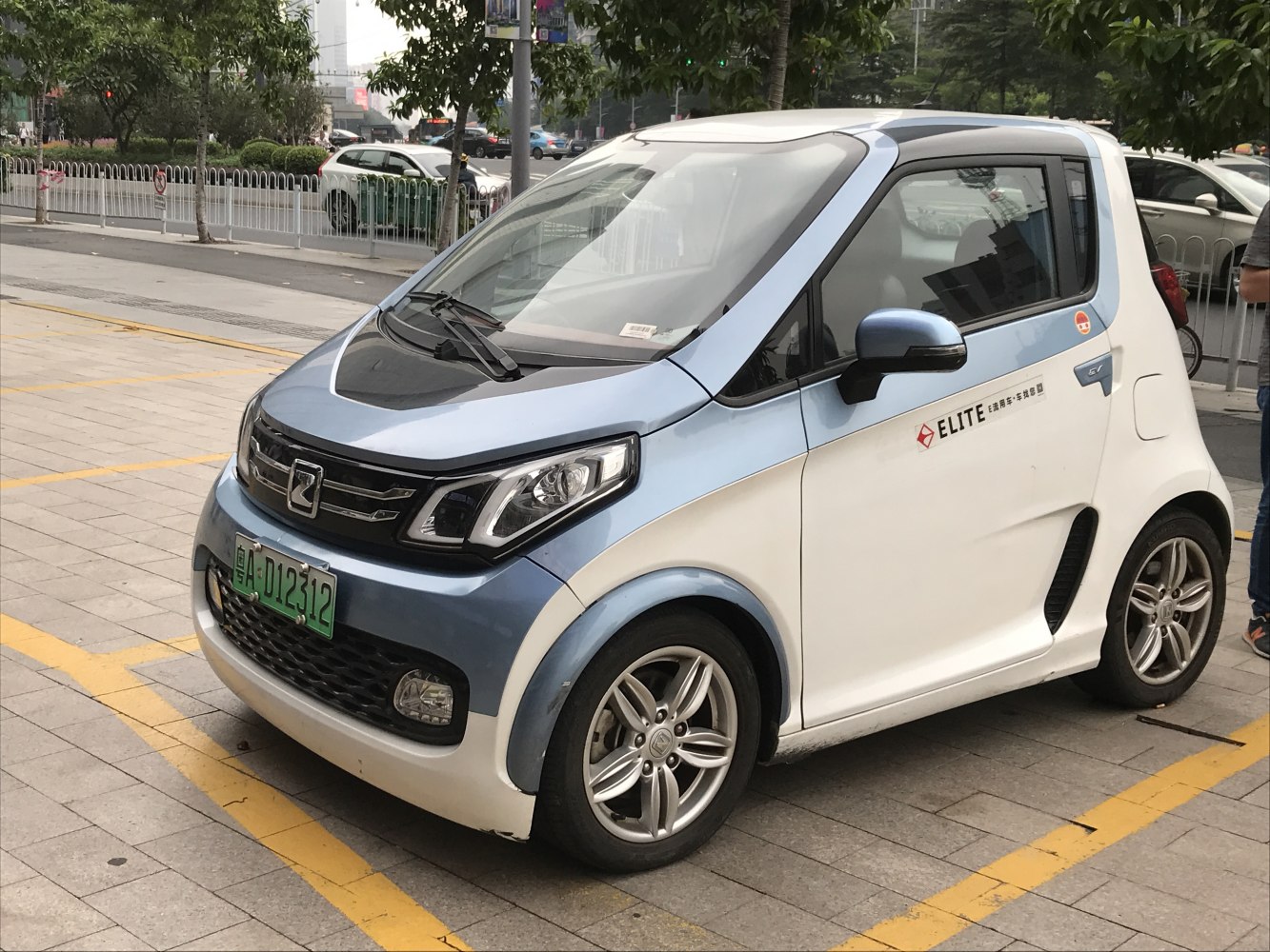 Compact electric vehicle, modern headlights, two-tone body, front-side view