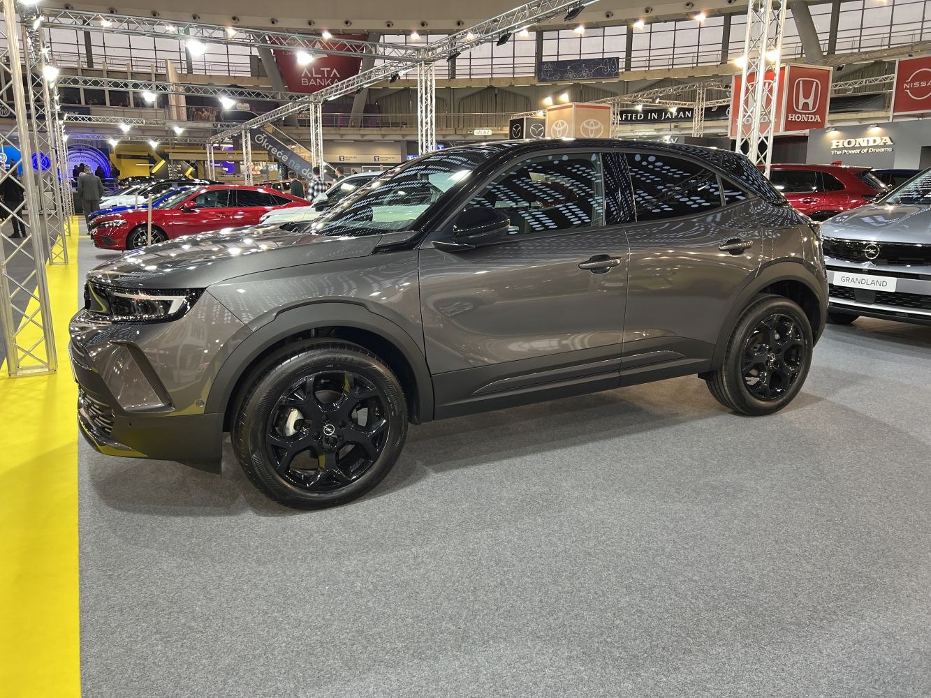 Sleek side profile with black alloy wheels and tinted windows