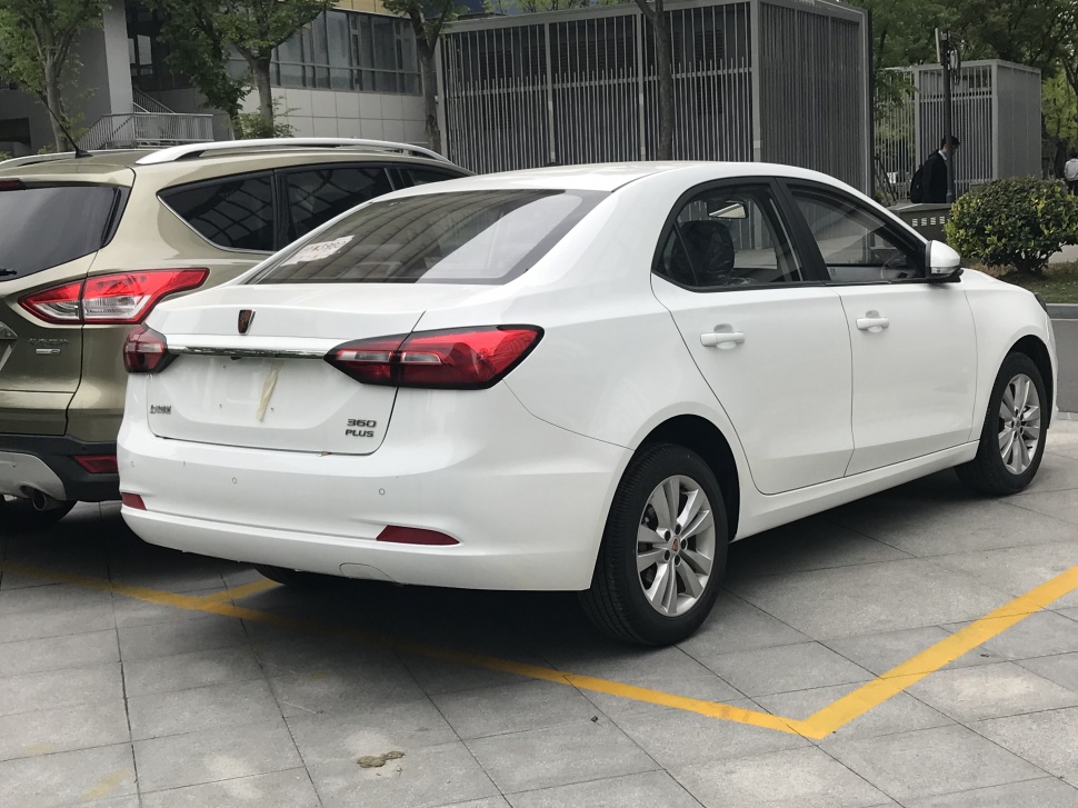 Rear and side view of a white sedan with modern tail lights and chrome trim