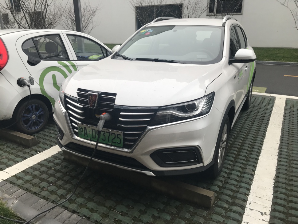 Electric SUV front view with charging cable and grille