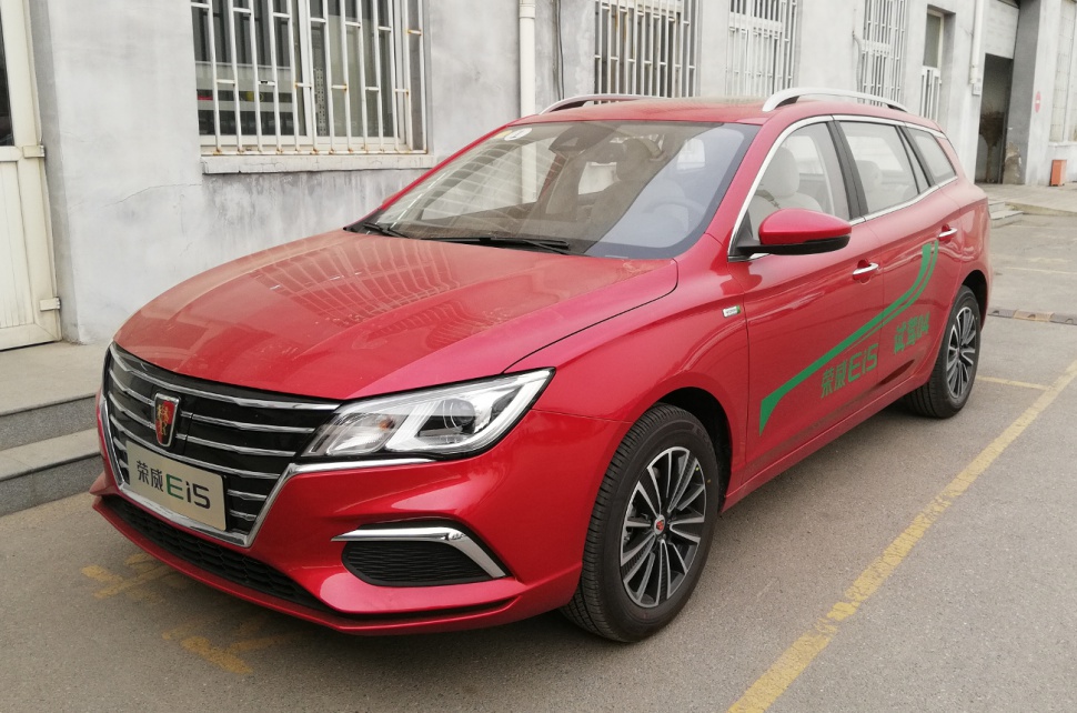 Red station wagon showing front side with sleek grille and modern headlights
