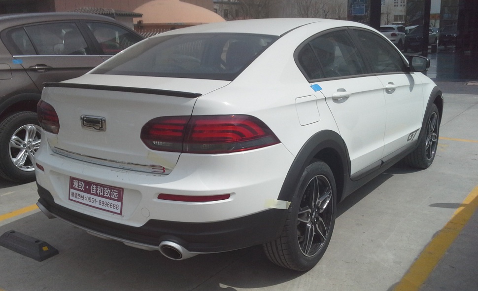 Rear view with dual exhaust, tail lights, black wheel arches, and trunk spoiler