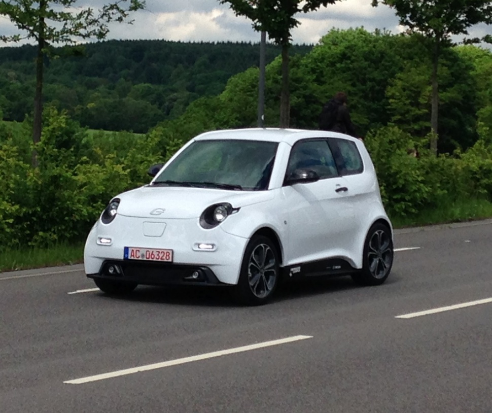 Compact electric city car with round headlights and sleek modern design.