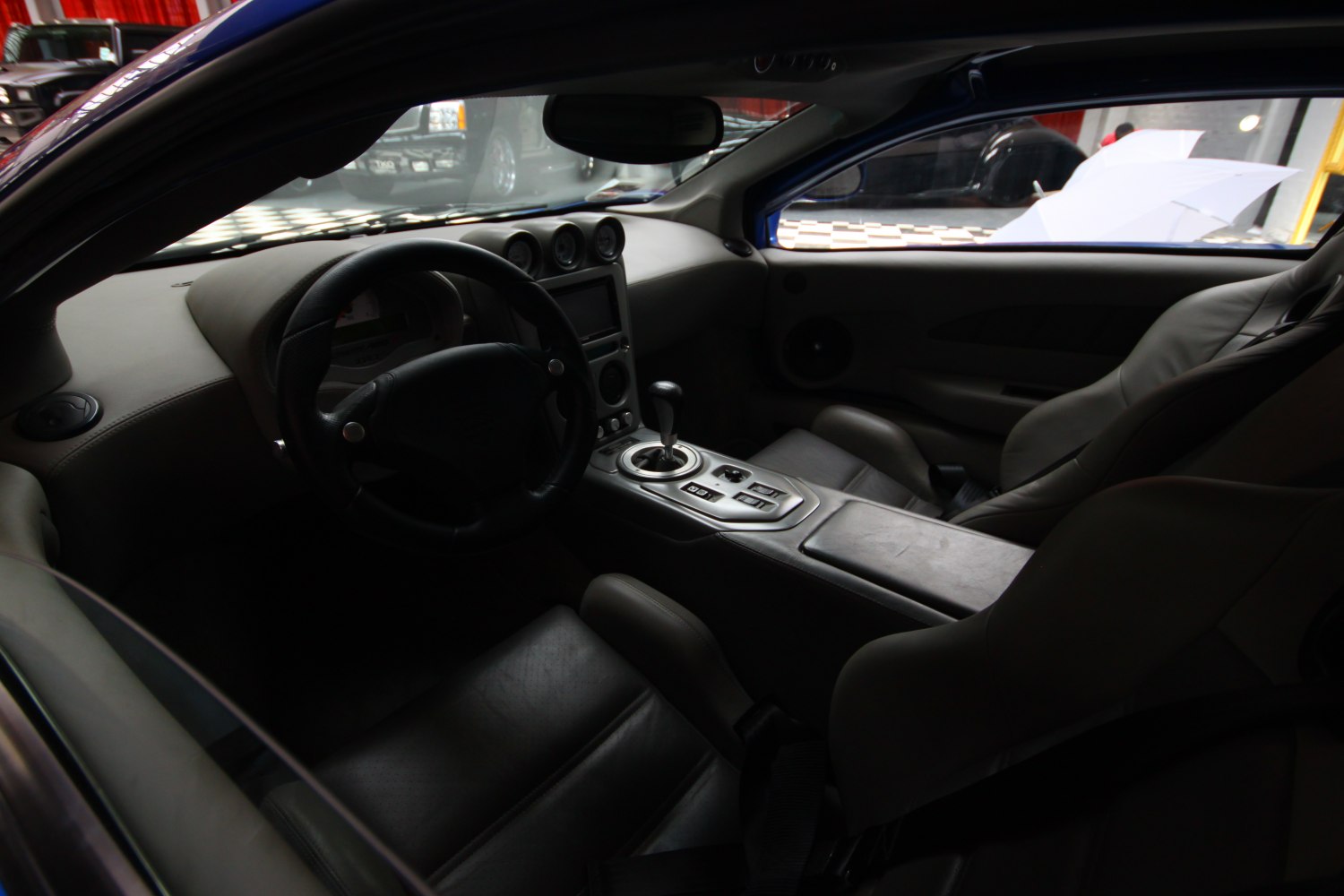 Leather seats and center console with gear shift inside a sports car