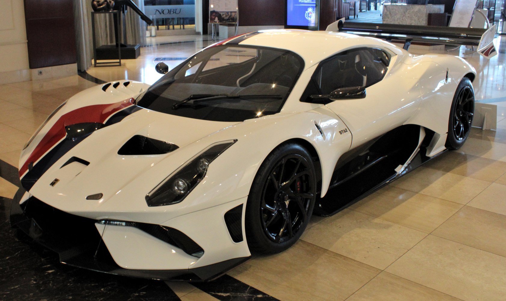 Aerodynamic sports car body with large rear wing and aggressive front air vents