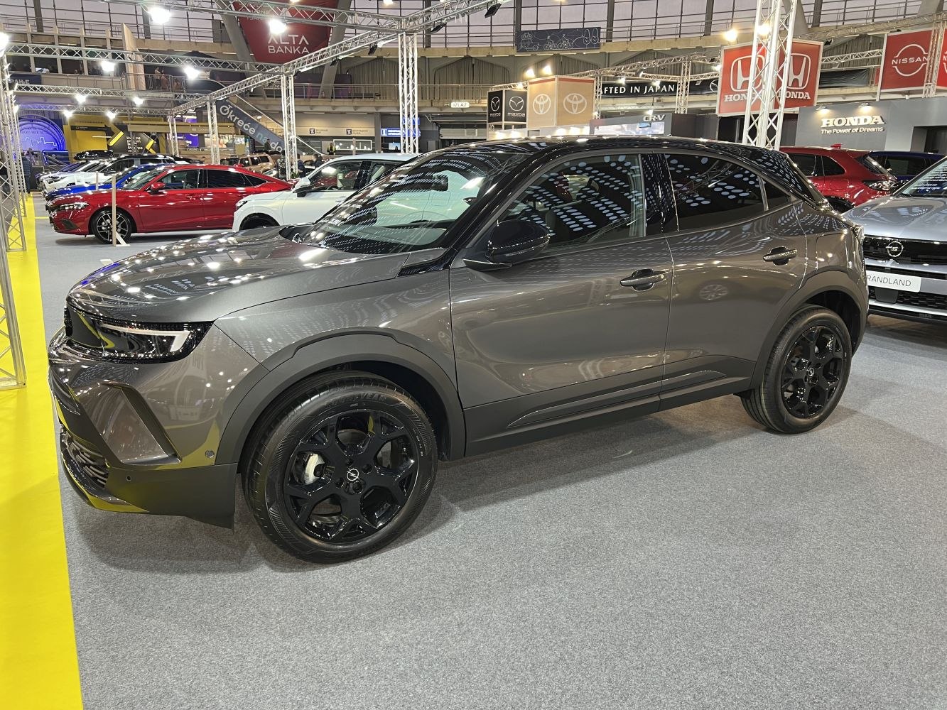 Side view of gray compact SUV with black alloy wheels and LED headlights