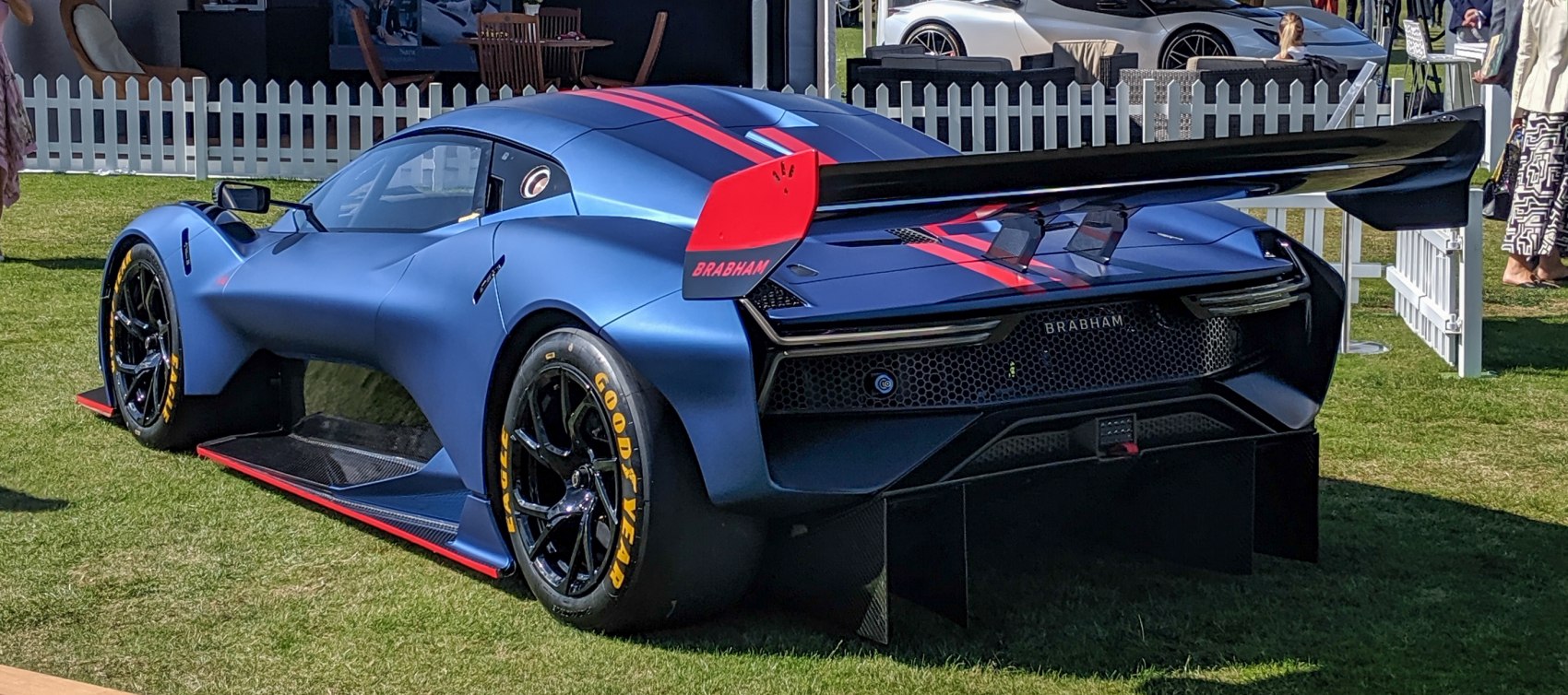 Rear view of a race car with large wing and Goodyear racing tires