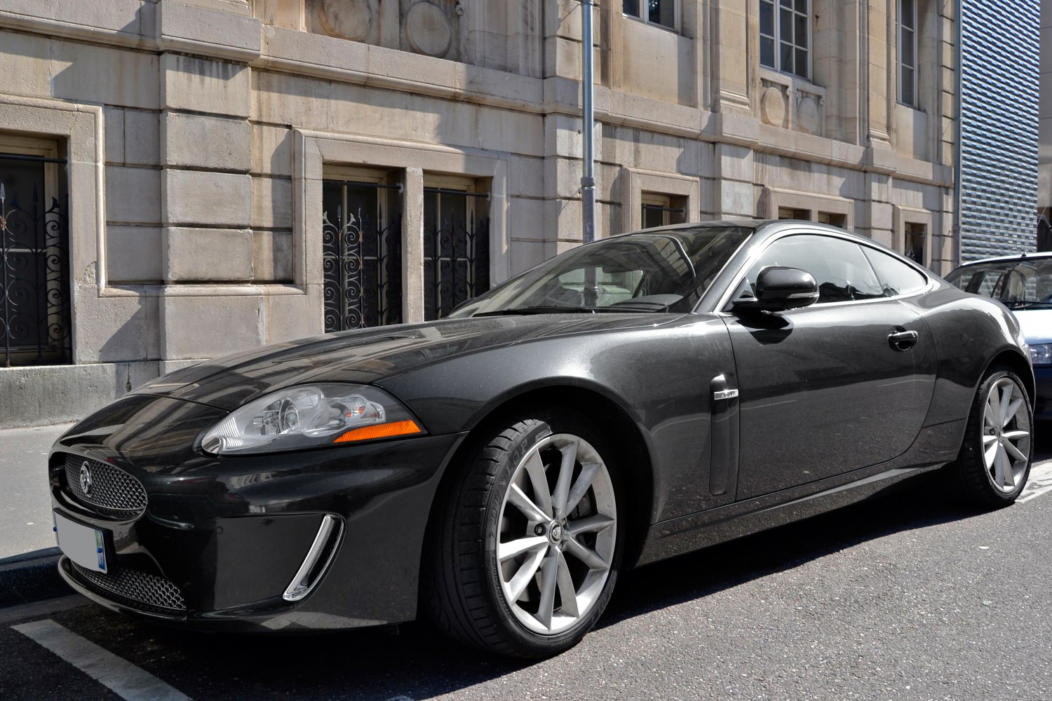 Sleek luxury coupe with alloy wheels shown in front-side view on street.