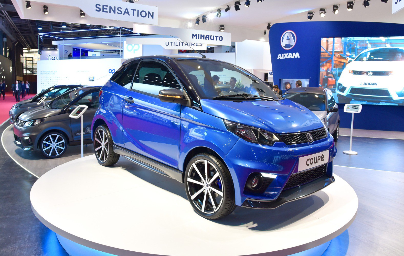 Blue compact coupe with sporty alloy wheels and LED running lights