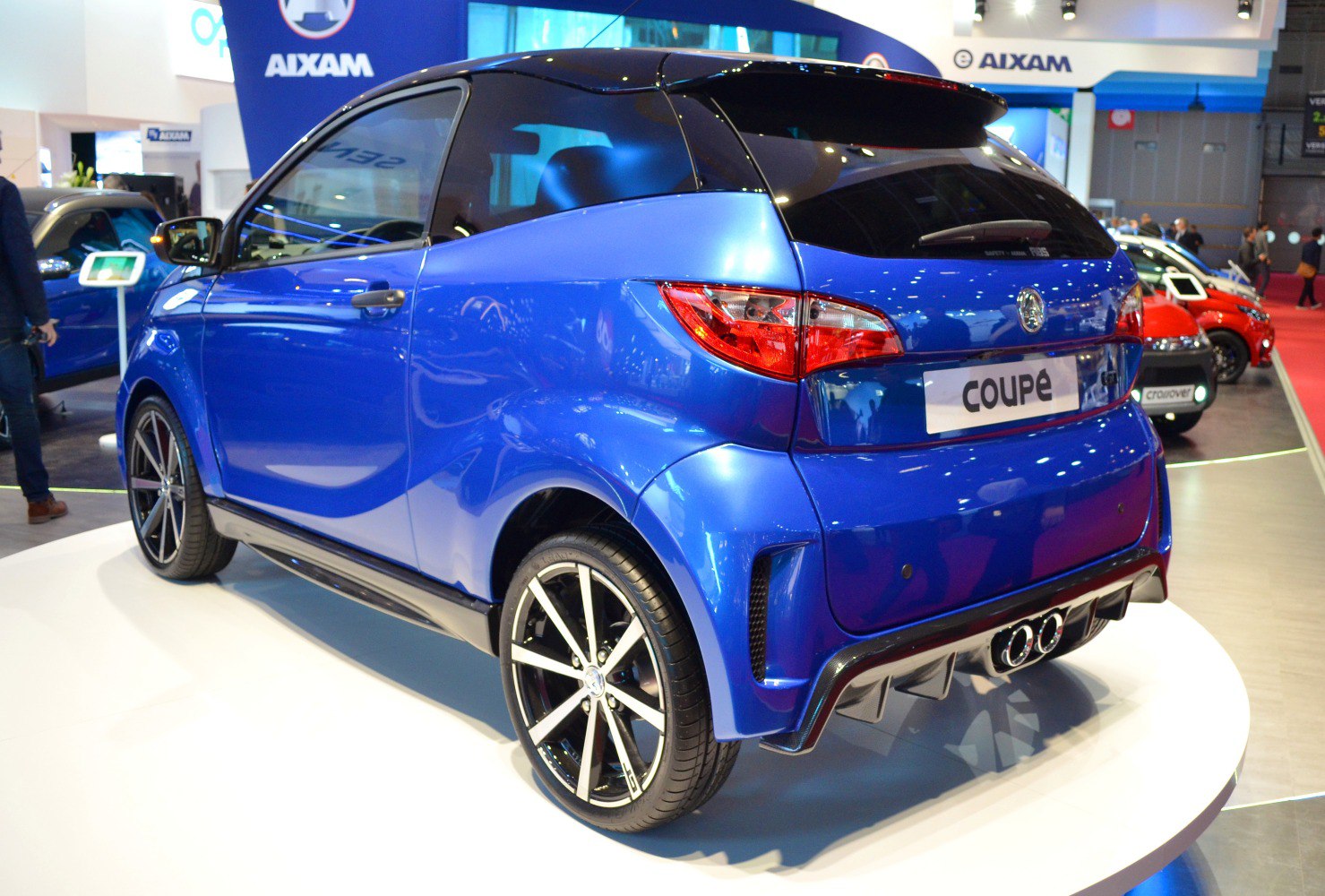 Rear view of a blue compact coupe with dual exhaust and alloy wheels