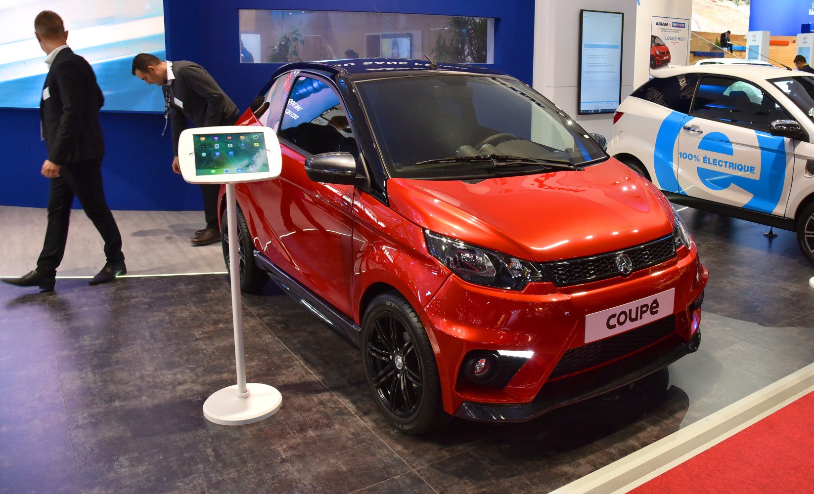 Red compact microcar with black roof and sporty coupe design