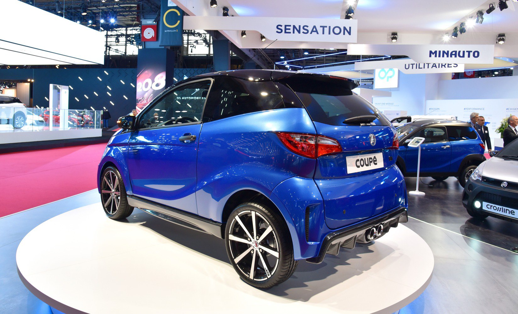 Compact urban microcar with sporty alloy wheels and sleek two-tone body.