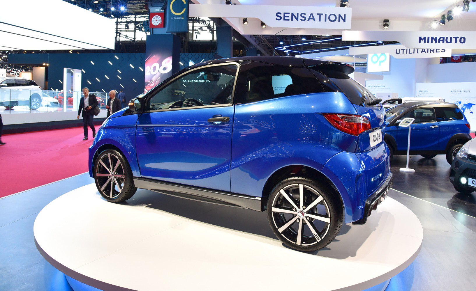 Compact blue two-door microcar with alloy wheels