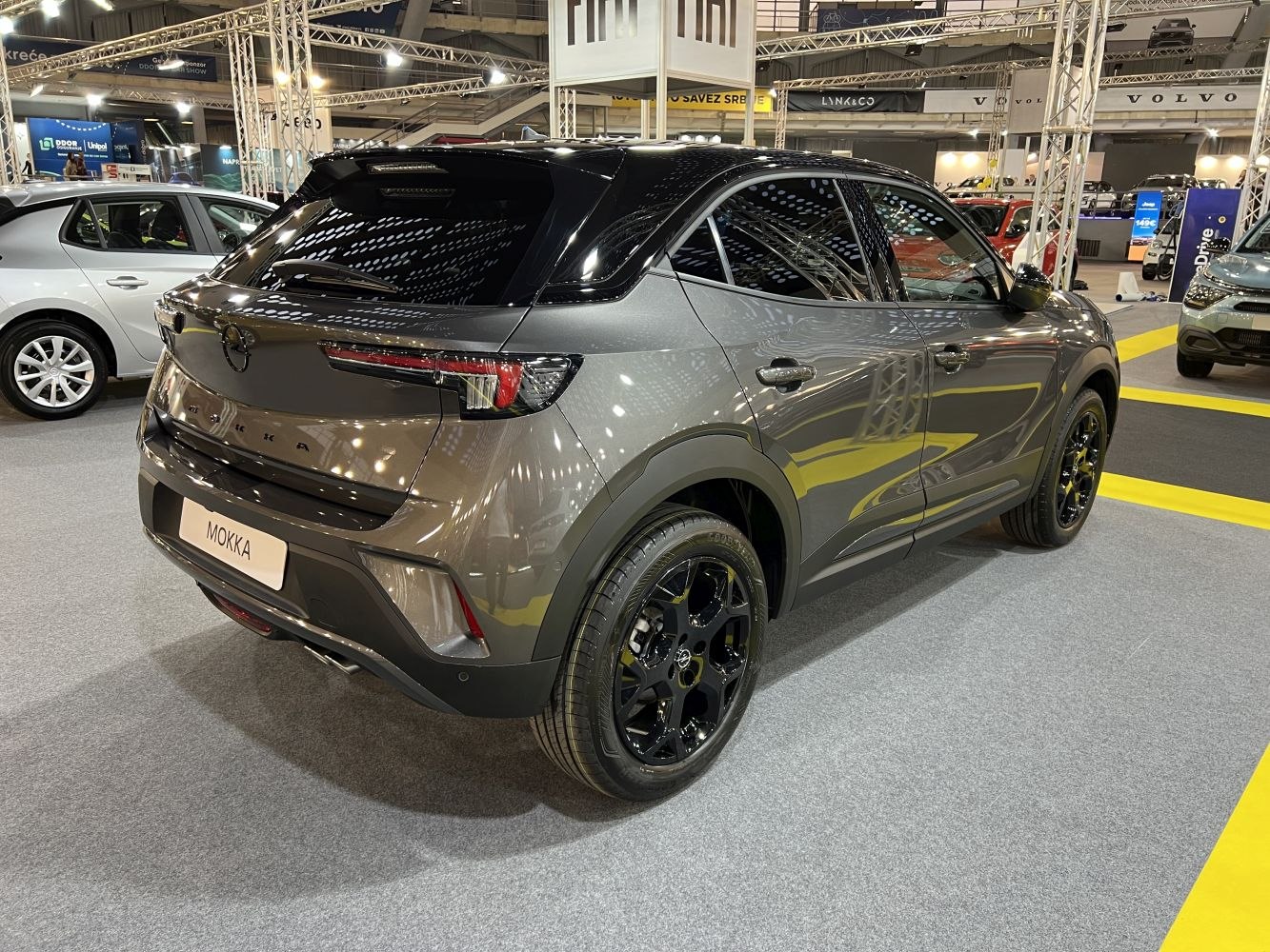 Sleek rear design with black alloy wheels and tinted windows.