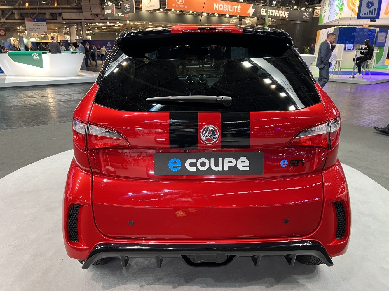 Rear view of sporty hatchback with black racing stripes and e-COUPE badge