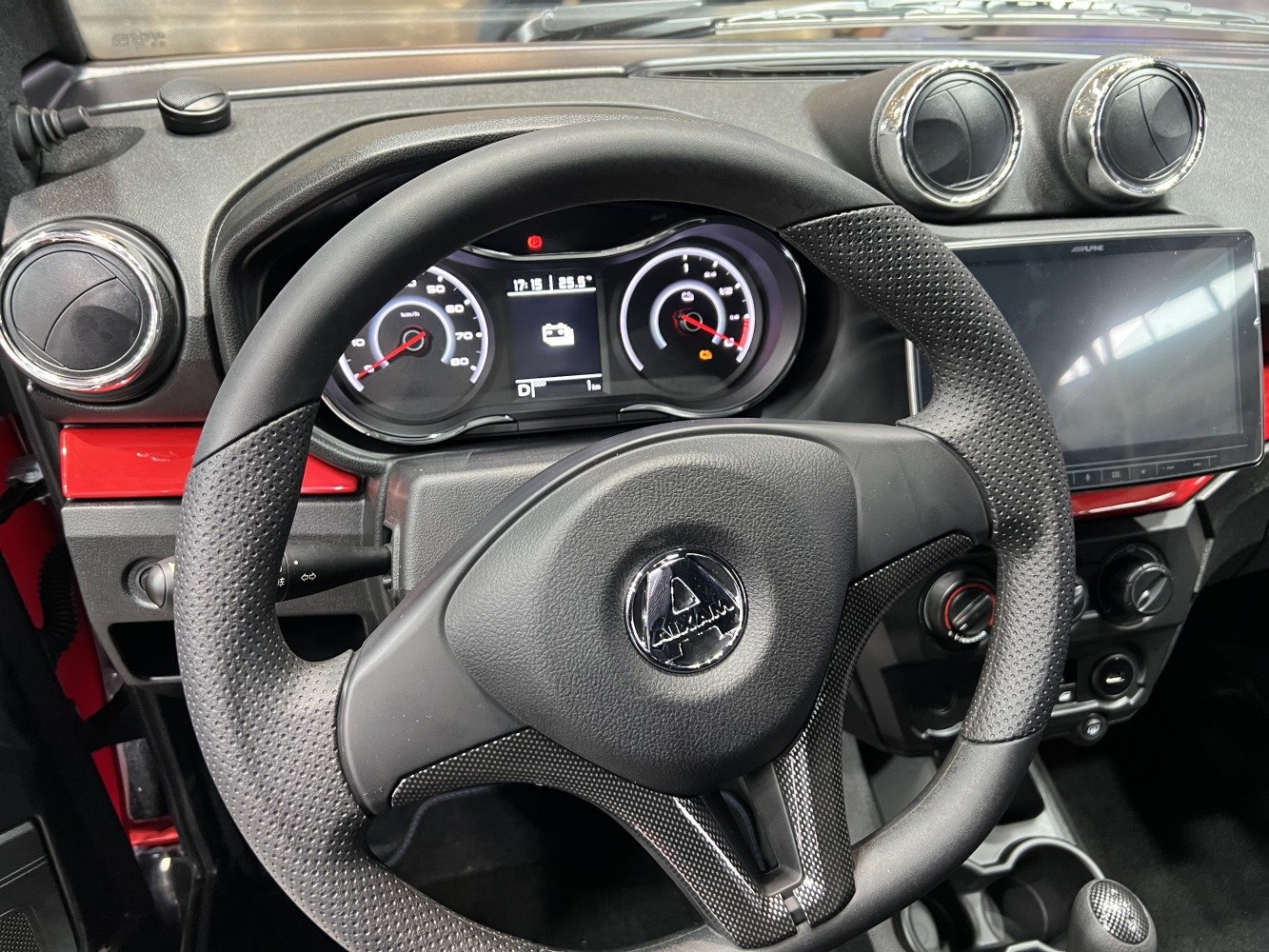 Steering wheel and dashboard with digital instrument cluster and infotainment system.