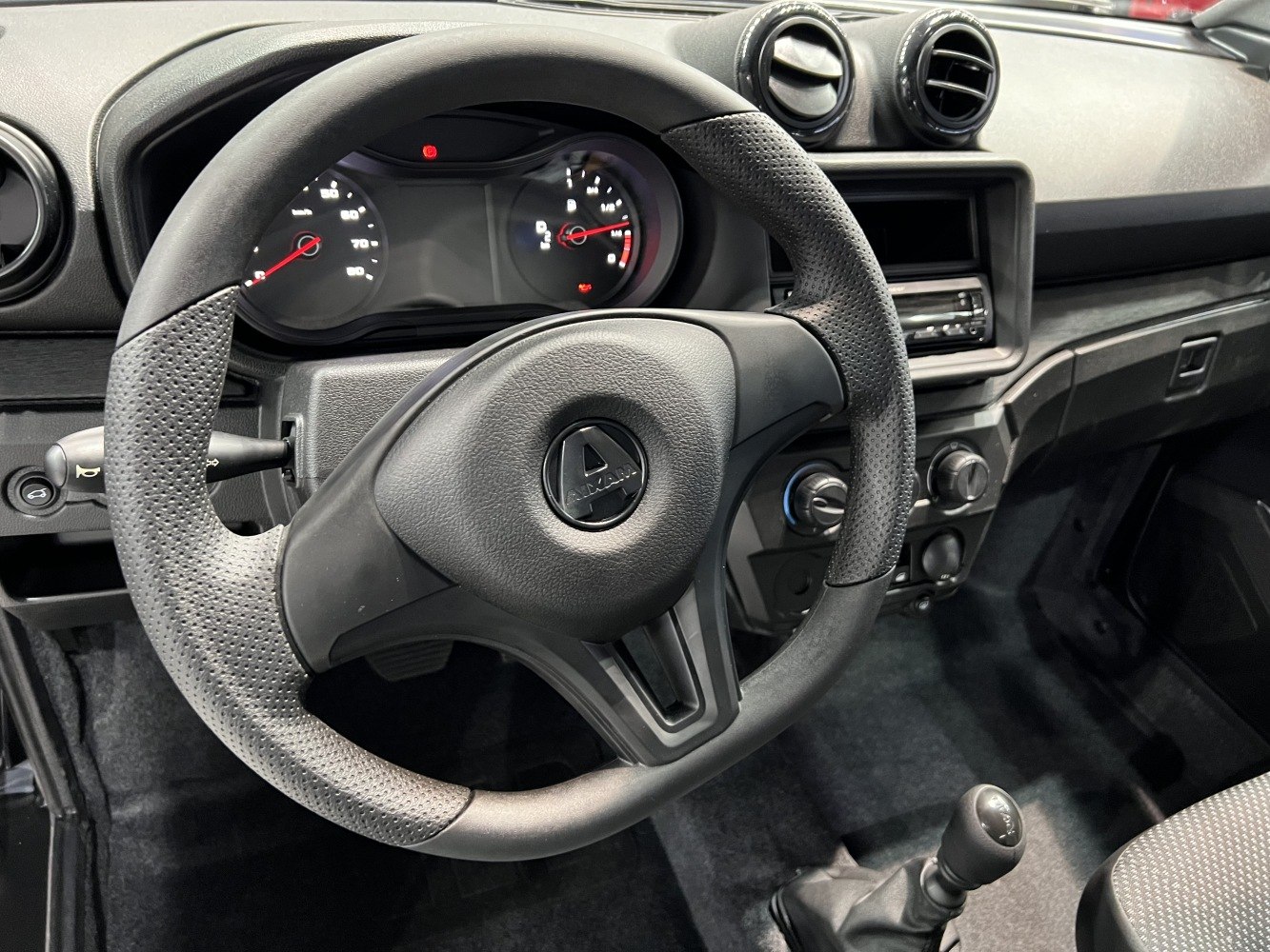 Interior dashboard with steering wheel, manual gear shift, and air vents
