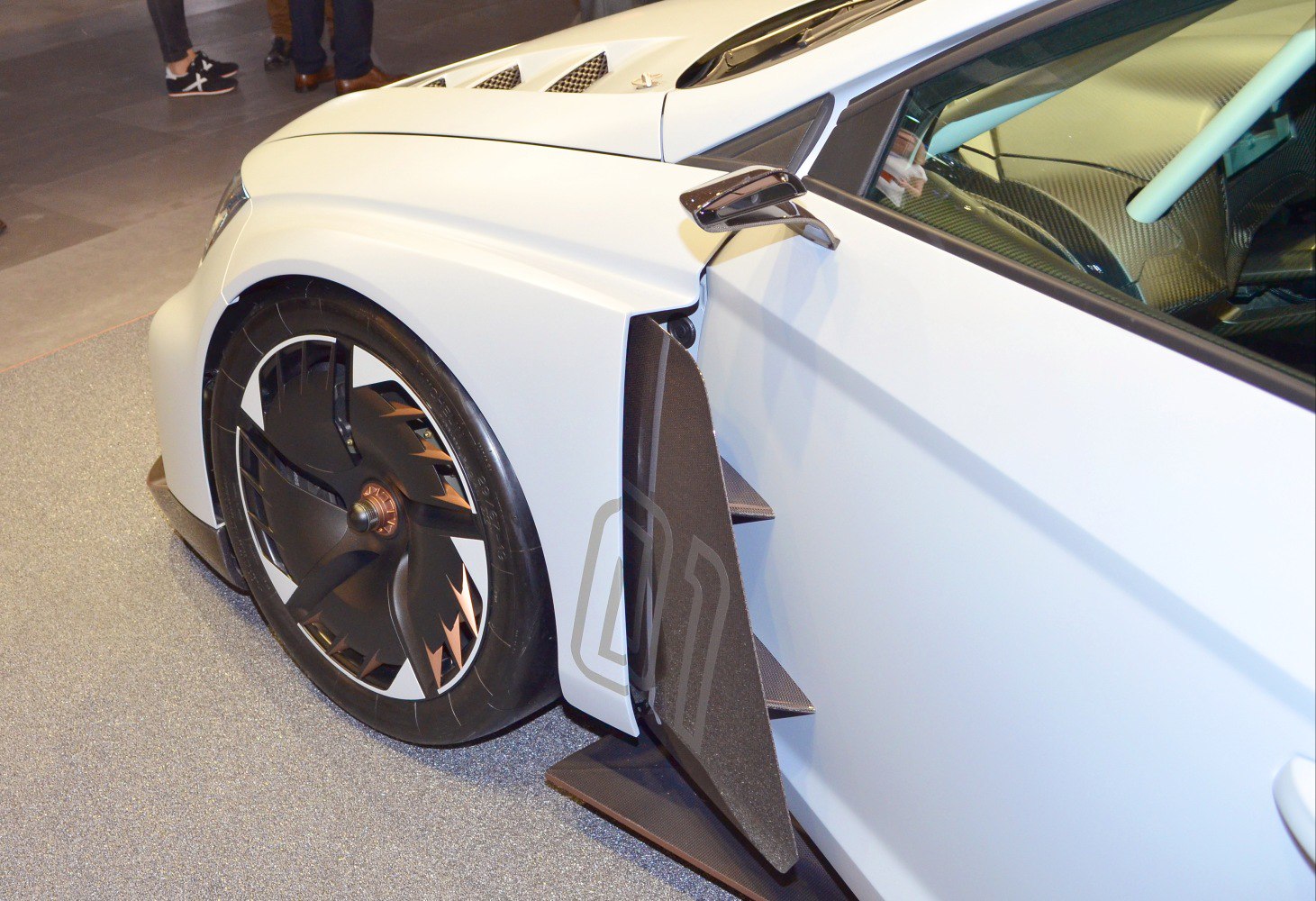 Front wheel with aerodynamic side fins and carbon fiber detailing