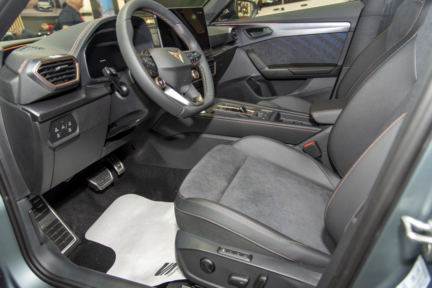 Modern car interior with dashboard, steering wheel, and front seats.