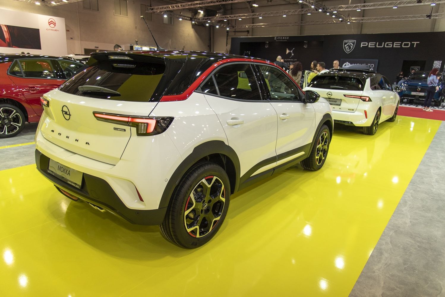 Rear and side view of white compact SUV with sporty wheels