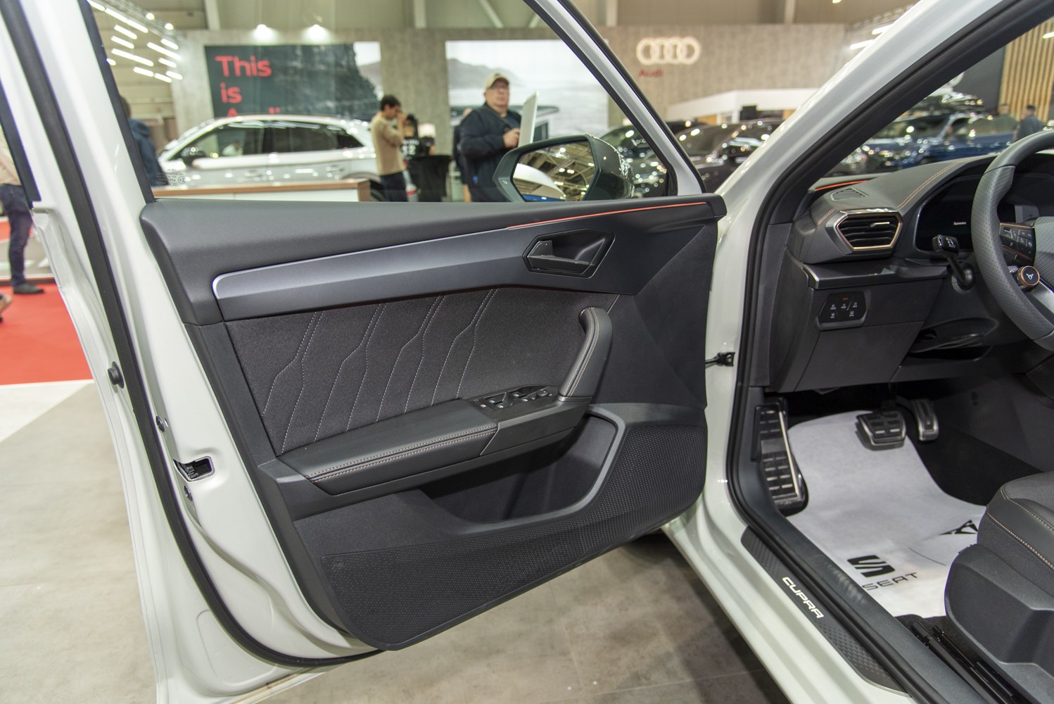 Interior door panel with power window controls and driver footwell visible.