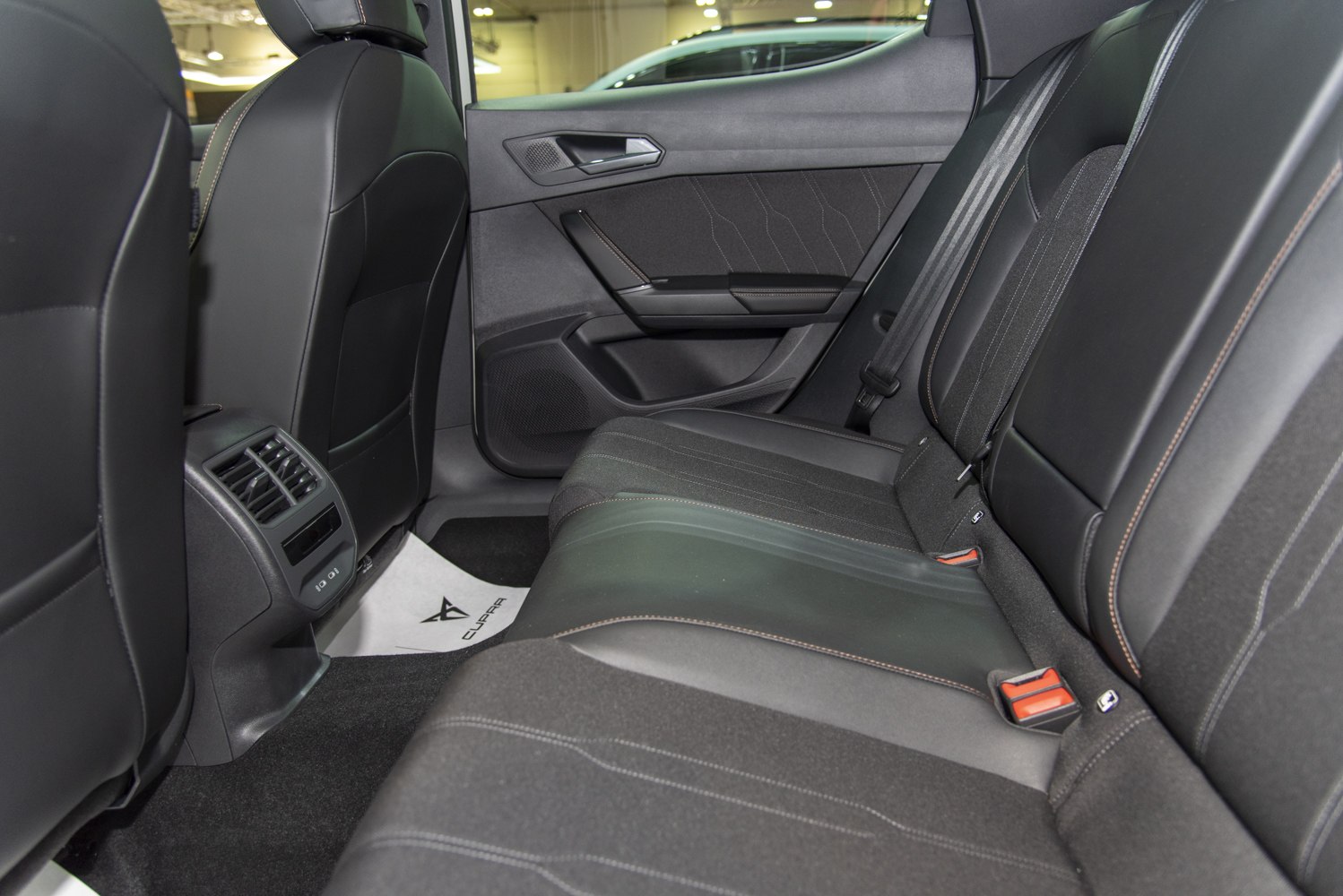 Rear seat interior with leather and fabric upholstery, rear air vents, modern door panel