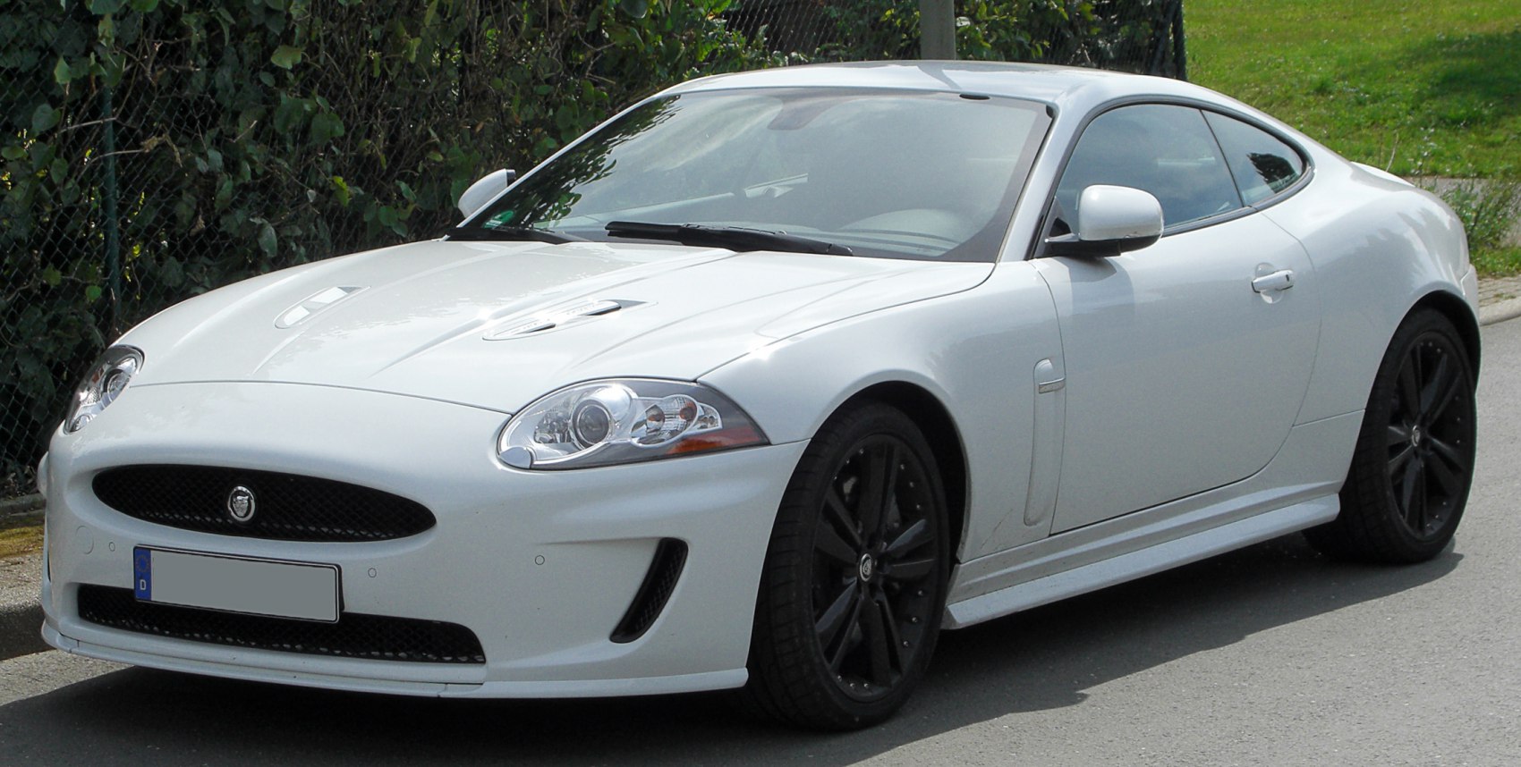Sleek white coupe with prominent headlights and black alloy wheels.