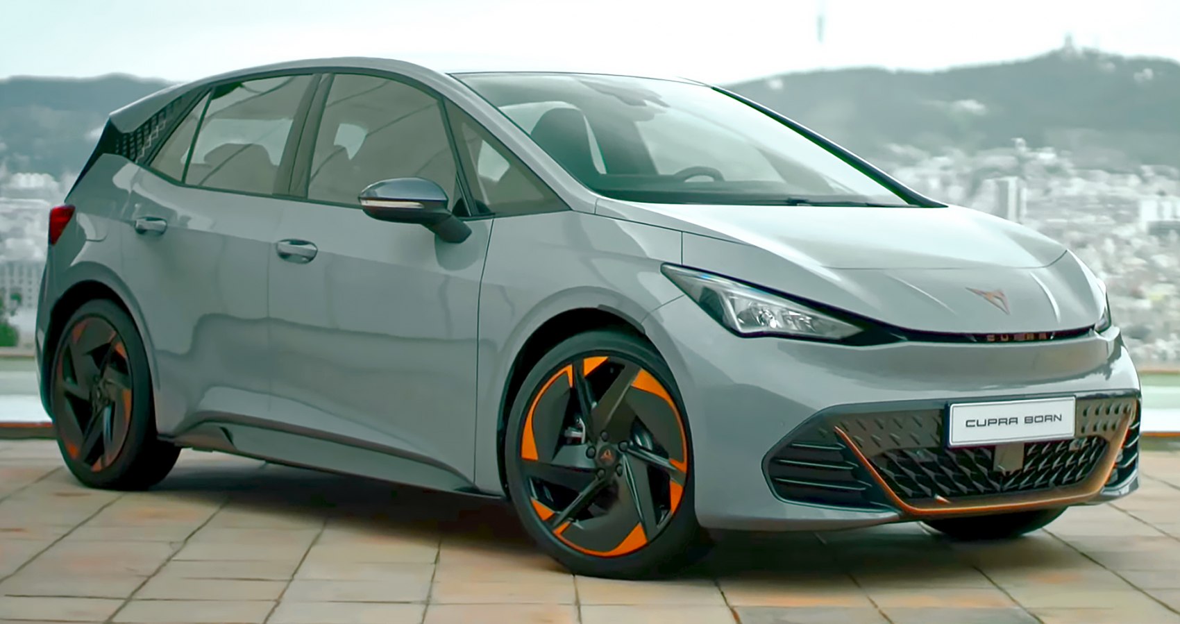 Front-side view of electric hatchback with orange-accented wheels