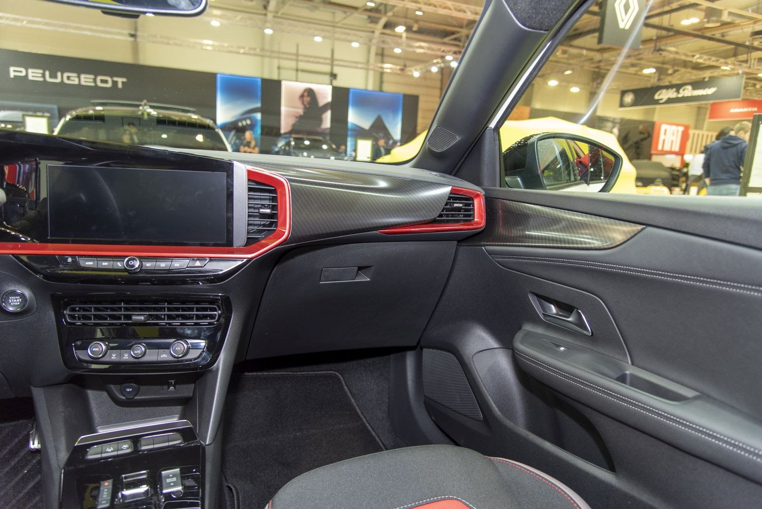 Dashboard touchscreen and door panel with red trim and carbon effect