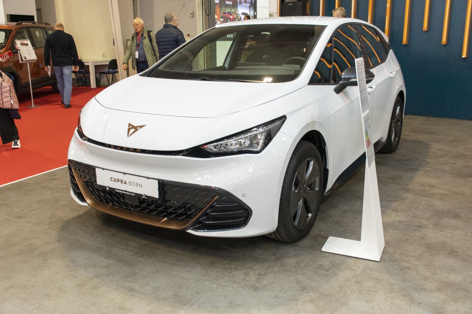 Front view of white electric hatchback with aerodynamic LED headlights.