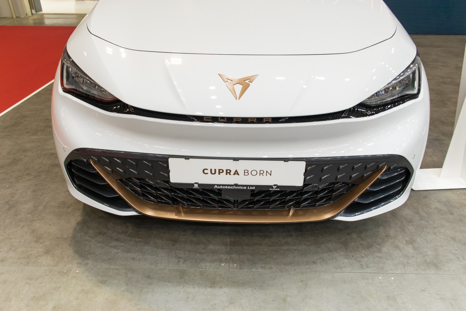 White front with sharp LED headlights and bronze-accented black grill.