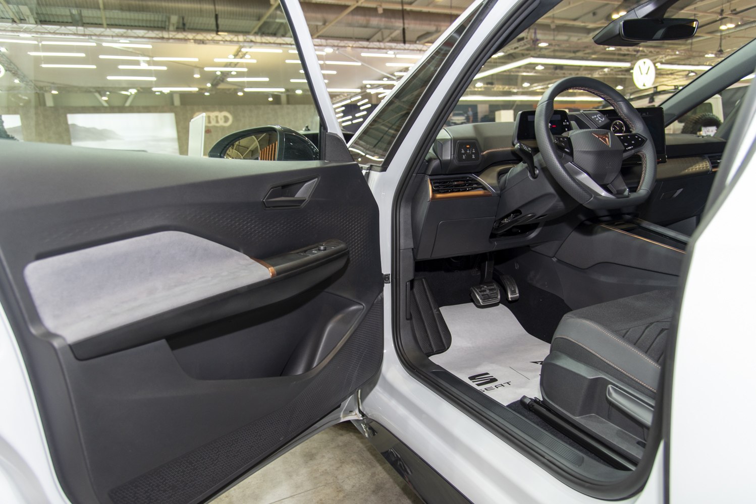 Driver side door panel and cockpit with steering wheel and pedals
