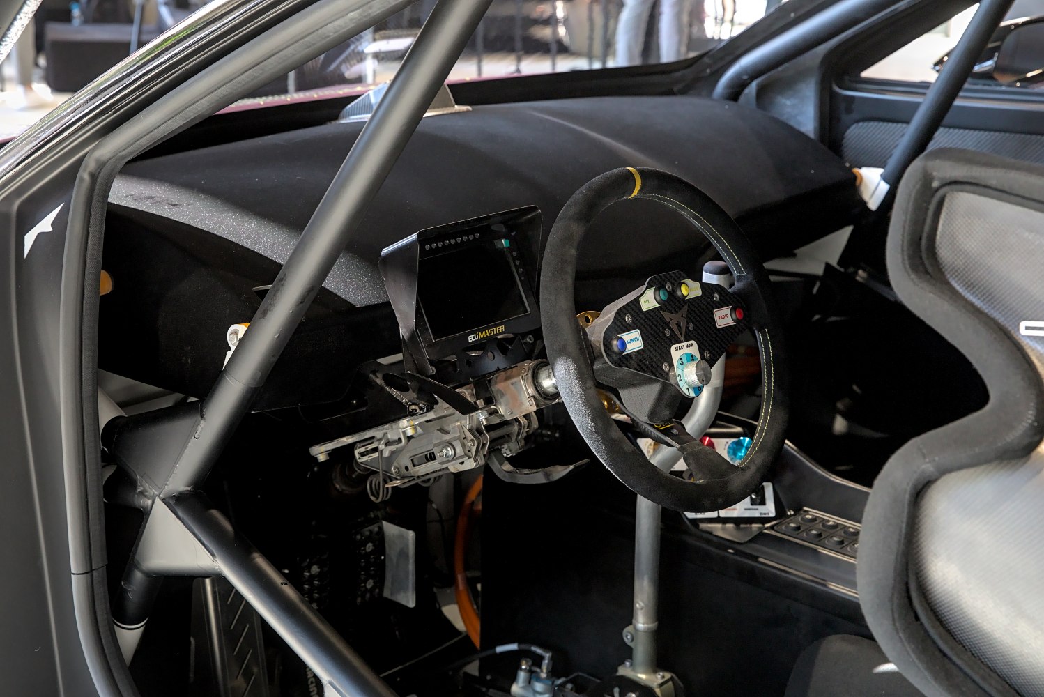 Race-style steering wheel and digital dashboard in a motorsport cockpit