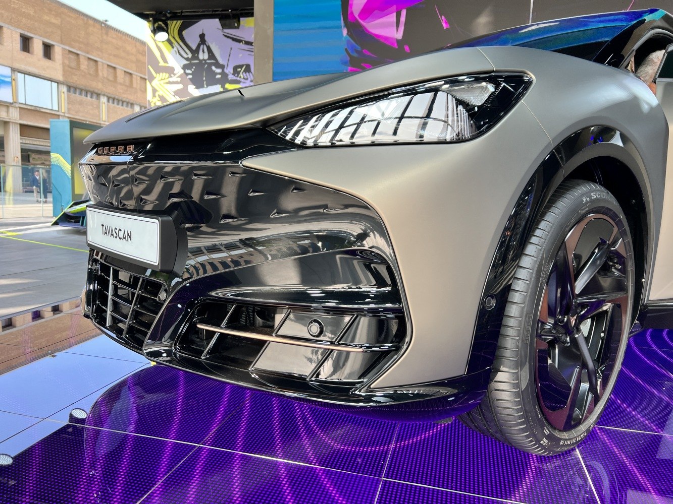 Close-up of modern headlights, grille, and wheel design of a vehicle front.