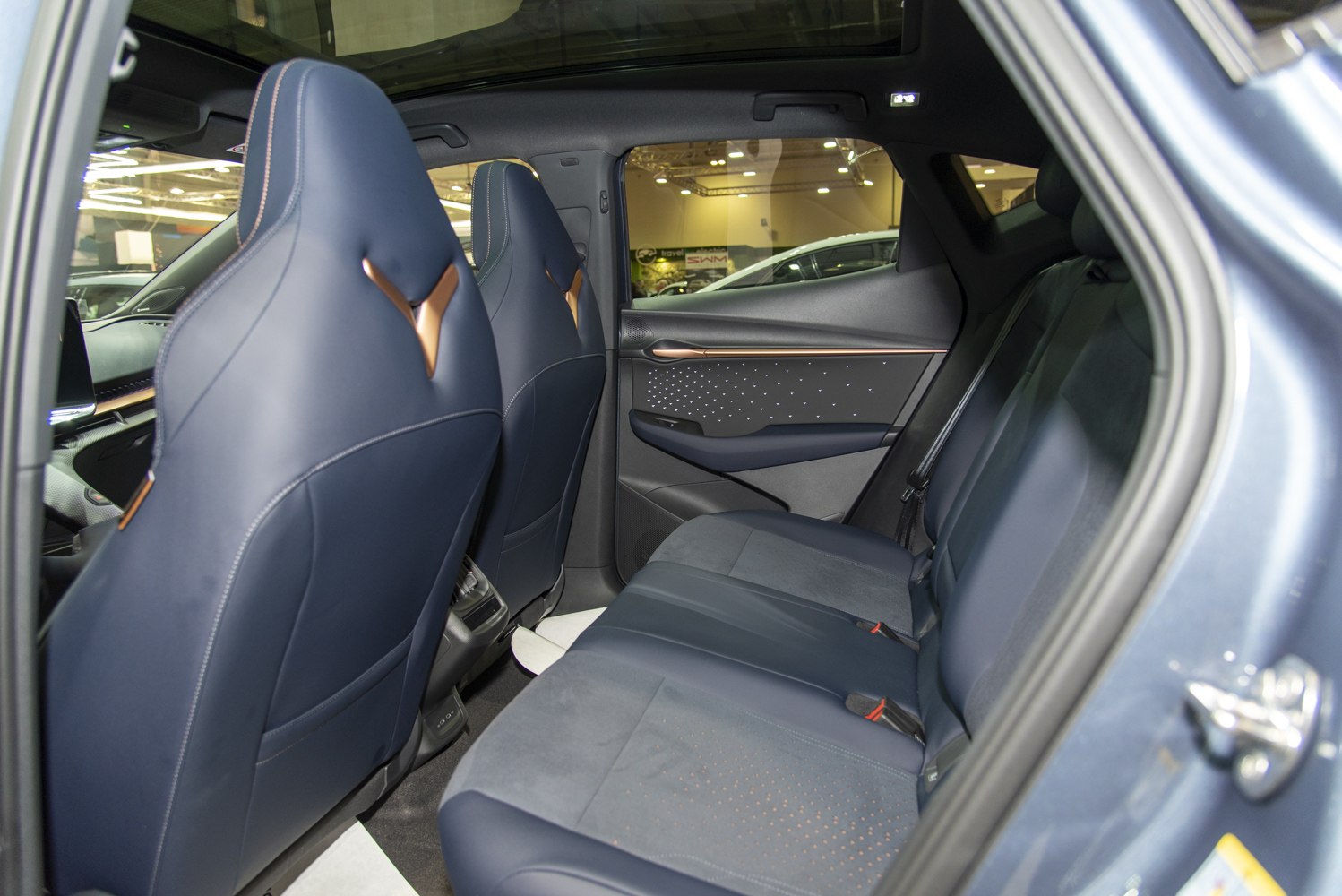 Rear seat area with stylish blue upholstery and modern door panel design.