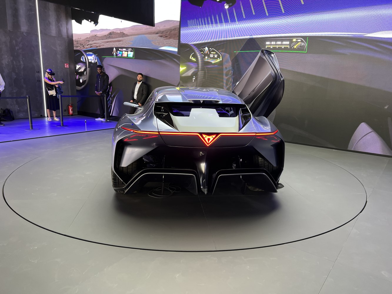 Futuristic sports coupe rear view with one scissor door open.
