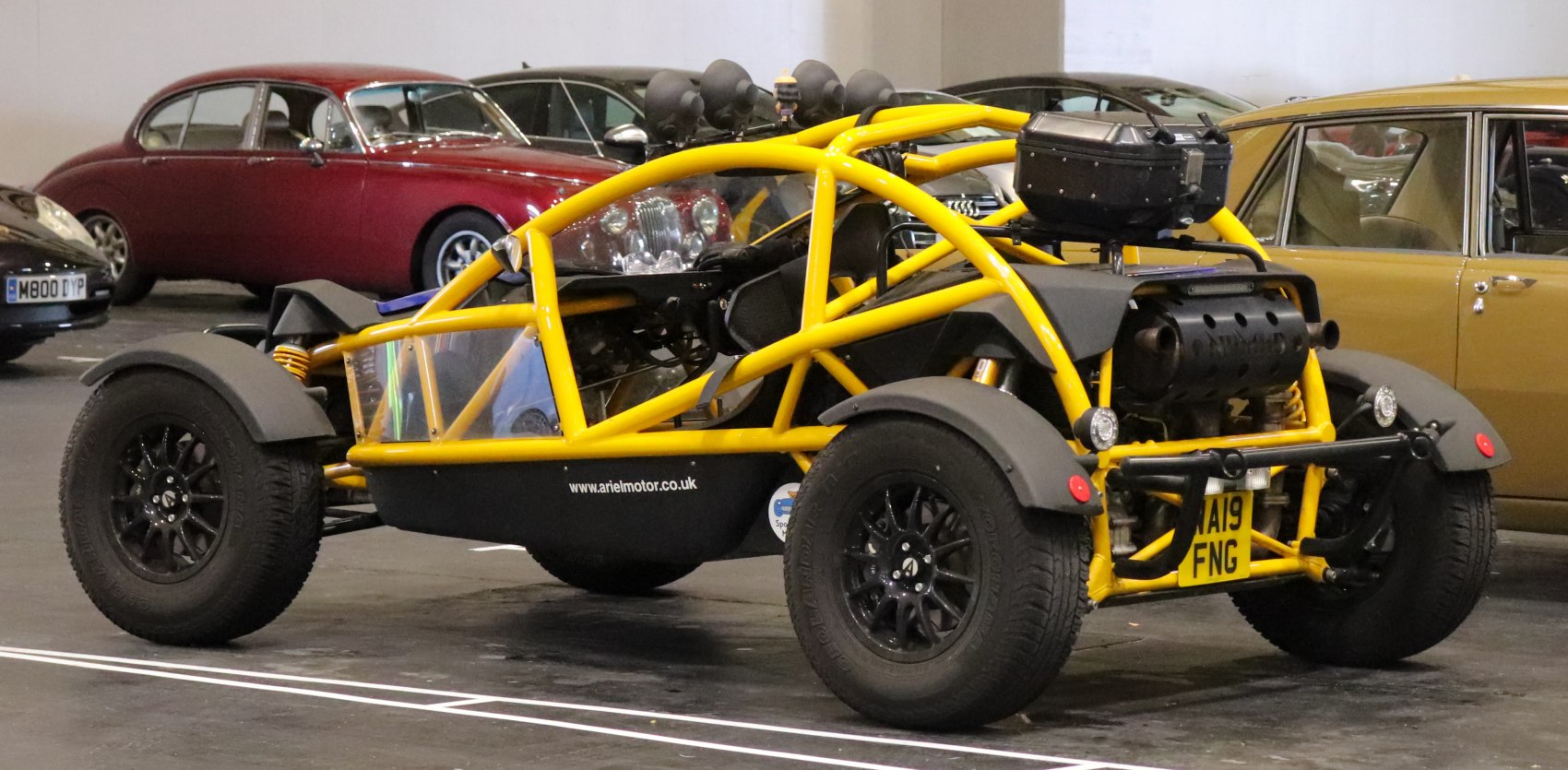 Yellow tubular frame and exposed roll cage with off-road tires