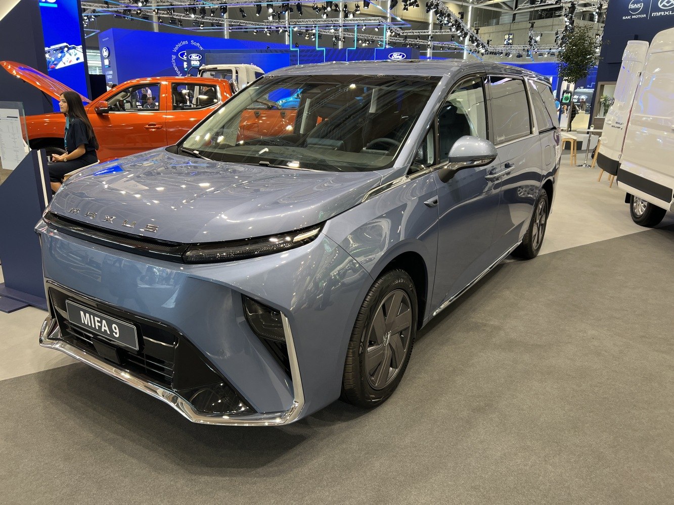Sleek front end of electric minivan with aerodynamic design and modern lighting.