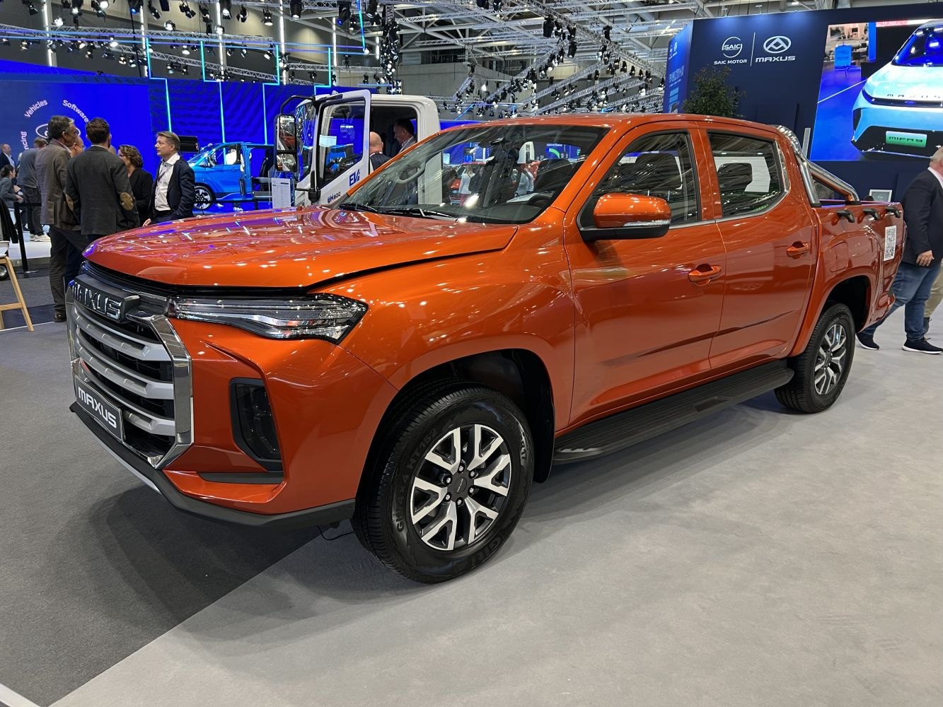 Orange double cab pickup with modern bold front grille and alloy wheels