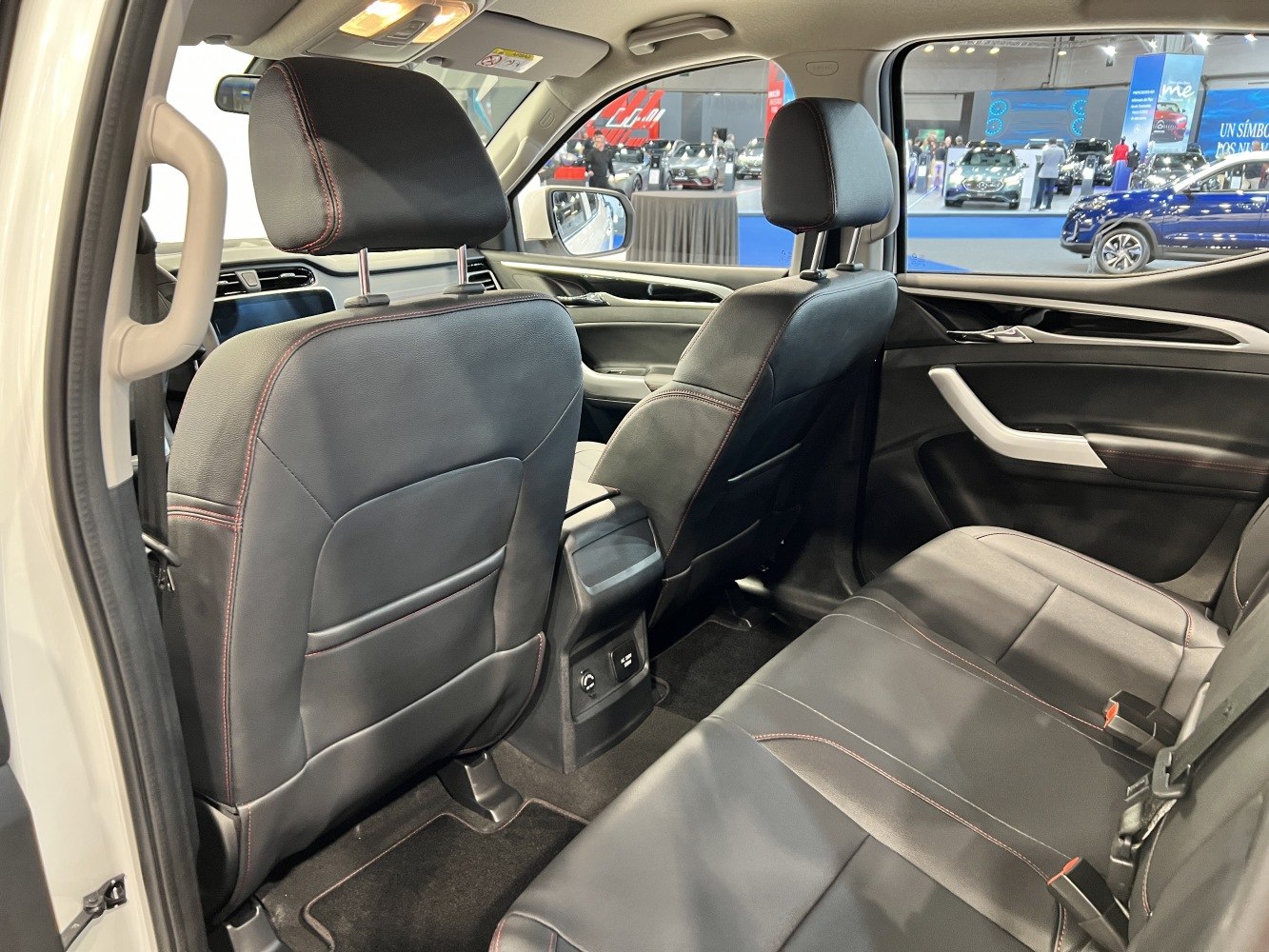 Rear cabin interior with black leather seats and red stitching