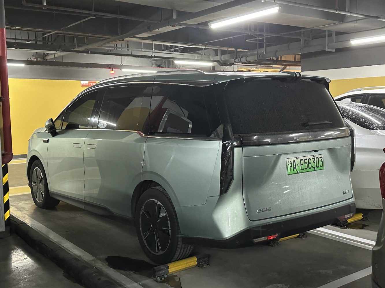 Rear and side profile of a modern electric SUV in a parking garage