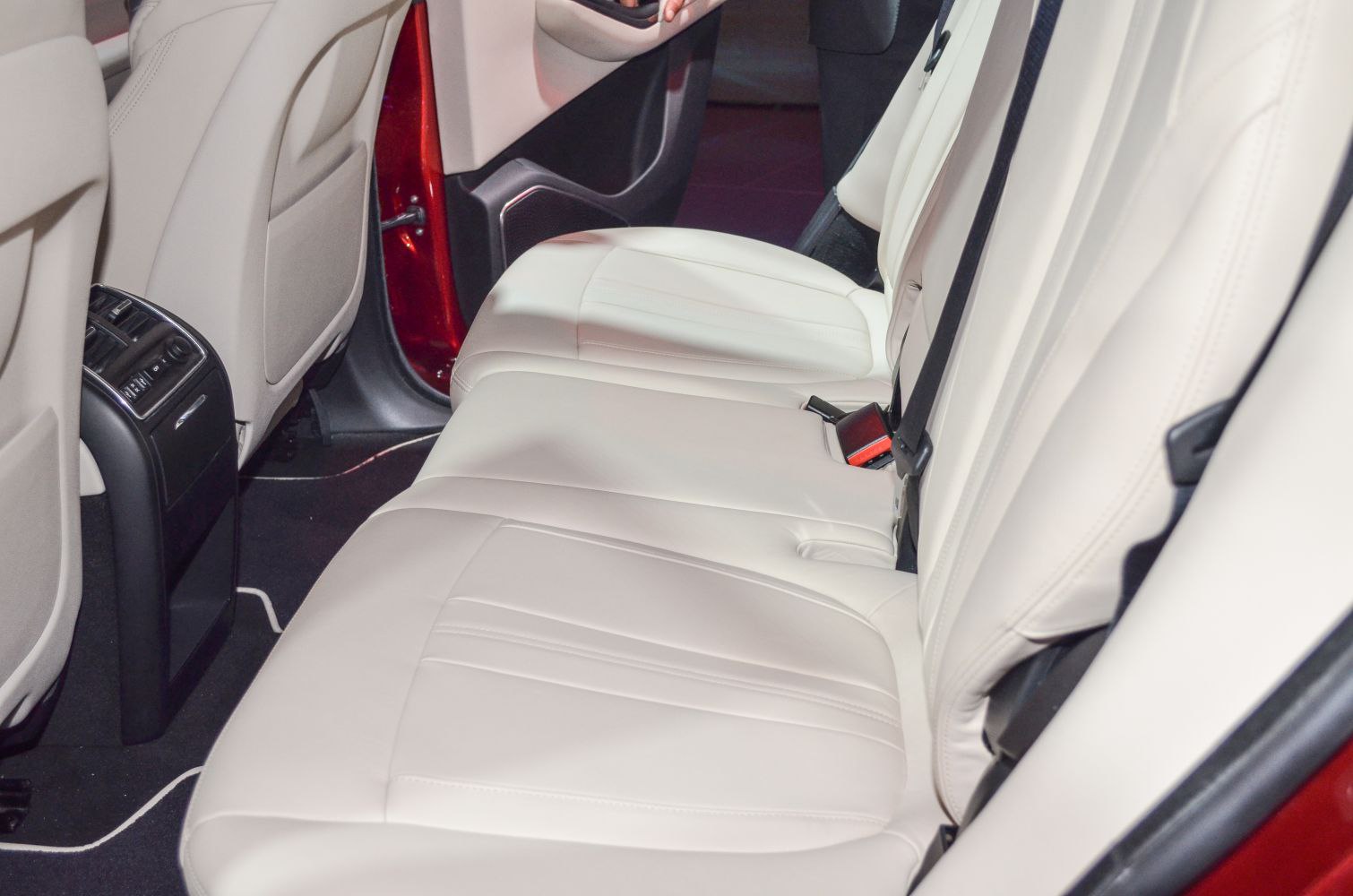 Beige leather rear seats with detailed stitching and door panel.