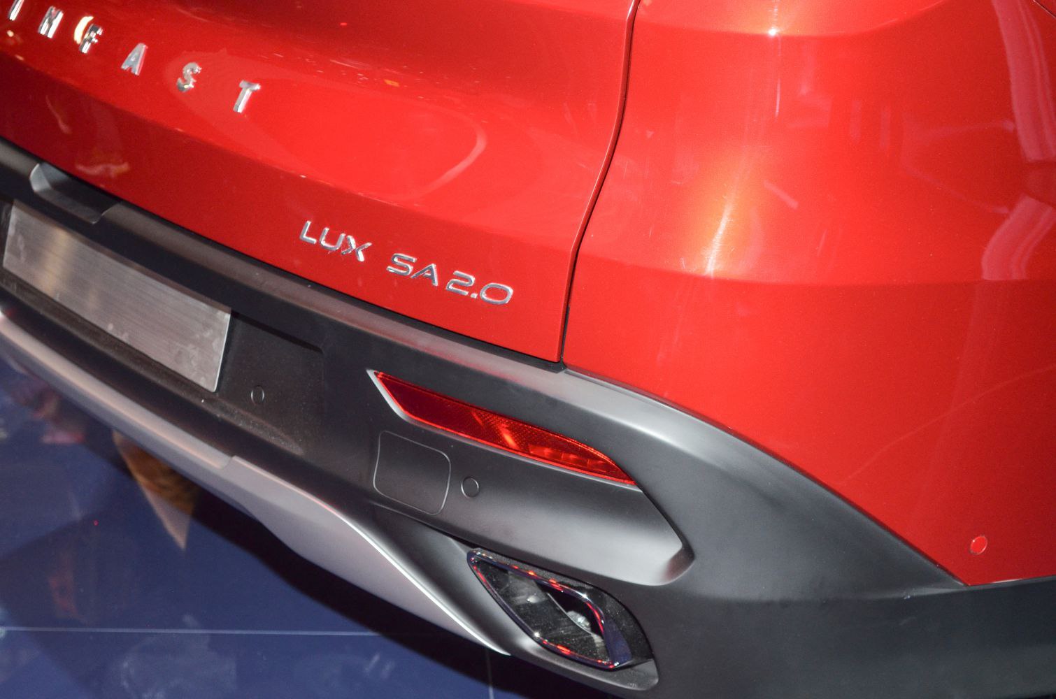 Close-up of rear bumper, reflector, exhaust, and logo badges